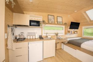 a kitchen and bedroom in a tiny house at Aurora Green Hill in Podobin