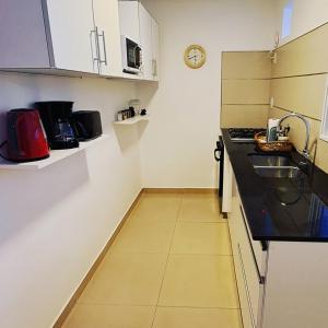 Una pequeña cocina con fregadero y encimera. en Departamento Centro Bahía, en Bahía Blanca