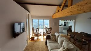 a living room with a couch and a table and chairs at Retiro Vale do Douro in Vila Marim