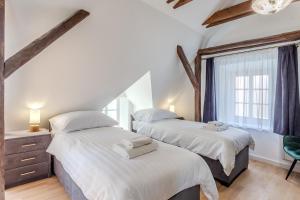 two twin beds in a room with a window at Fulop Panzio Rooms in Révfülöp