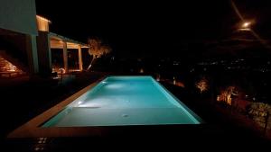 an empty swimming pool at night with a building at Retiro Vale do Douro in Vila Marim