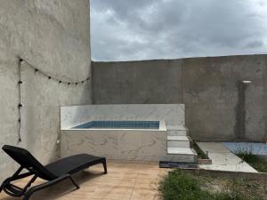 a chair sitting on a patio with a swimming pool at La Casita del Sol in Crucita