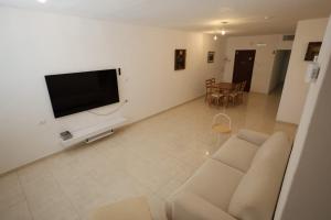 a living room with a couch and a flat screen tv at Vacation rental in Netanya
