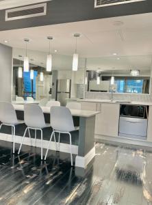 a kitchen with a table and white chairs in it at Stylish Family 1BR with Cozy Bunks and Games for 5 in Sydney