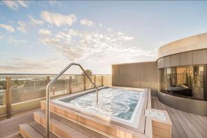 a hot tub on the balcony of a building at Stylish Family 1BR with Cozy Bunks and Games for 5 in Sydney