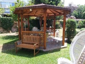a wooden gazebo with a bench in a yard at Charm & comfort in Nettuno +11 photos
