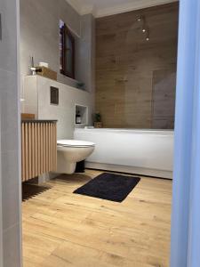 a bathroom with a tub and a toilet and a sink at Casa de Vacanta Cris in Băile Olăneşti +24 photos