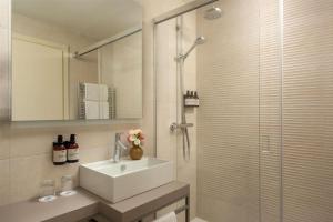 a bathroom with a sink and a glass shower at NH Trieste in Trieste