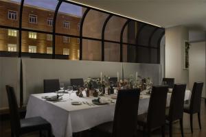 a dining room with a table with chairs and candles at NH Trieste in Trieste