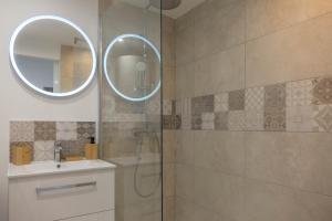 a bathroom with a shower and a sink and a mirror at Le Naturel, Cocon Calme au Centre-ville in Montargis