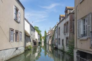 a narrow canal between two buildings in a city at Le Naturel, Cocon Calme au Centre-ville in Montargis