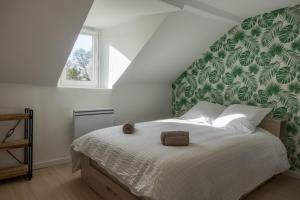 a bedroom with a large bed with a green headboard at Le Naturel, Cocon Calme au Centre-ville in Montargis