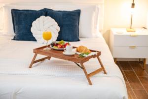 una bandeja de comida y un vaso de zumo de naranja en la cama en Steps to Beach, Heated Pool, 2 Queen Beds, 2BA, en St Pete Beach