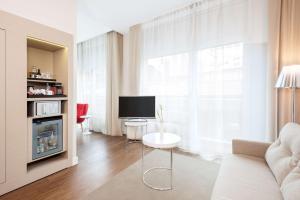 a living room with a couch and a television at NH Collection Berlin Mitte Friedrichstrasse in Berlin