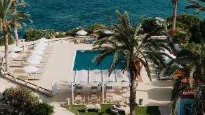 an aerial view of a resort with a pool and the ocean at Vrachia Beach Hotel & Suites - Adults Only in Paphos
