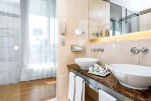 a bathroom with a sink and a mirror at NH Collection Berlin Mitte Friedrichstrasse in Berlin