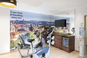 a gym with a wall mural of a city at NH Collection Berlin Mitte Friedrichstrasse in Berlin