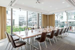 a conference room with a long table and chairs at NH Collection Berlin Mitte Friedrichstrasse in Berlin