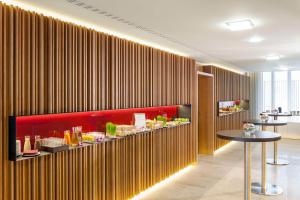 a restaurant with a wall covered in vertical wood panels at NH Collection Berlin Mitte Friedrichstrasse in Berlin