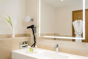 a bathroom with a sink and a mirror at NH Collection Berlin Mitte Friedrichstrasse in Berlin