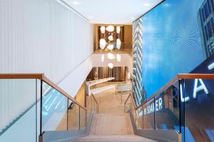a staircase in a building with a blue wall at NH Collection Berlin Mitte Friedrichstrasse in Berlin