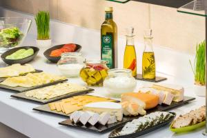 a table with different types of cheese and bottles of alcohol at NH Collection Berlin Mitte Friedrichstrasse in Berlin