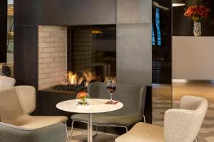 a table with a glass of wine next to a fireplace at NH Collection Berlin Mitte Friedrichstrasse in Berlin