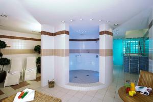 a large bathroom with a tub in the middle at NH Collection Berlin Mitte Friedrichstrasse in Berlin