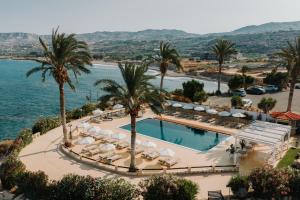 an aerial view of a resort with a pool and palm trees at Vrachia Beach Hotel & Suites - Adults Only in Paphos