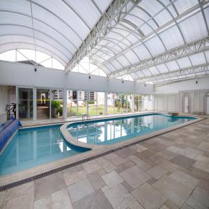 a large swimming pool with a glass ceiling at Hotel Chateau in Campos do Jordão