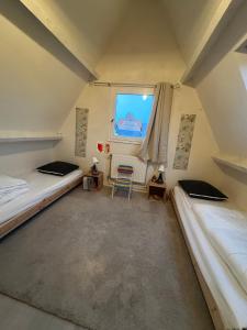 a room with two beds and a window at Cottage with Garden 5mn Beach in Cabourg