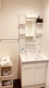 a white bathroom with a sink and a toilet at SkyHotel Kikukawa 駅徒歩2分 in Tokyo