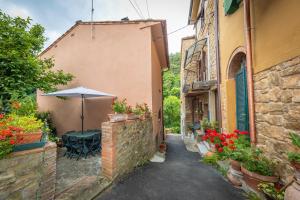 an alley with a table and an umbrella at Casa Antica Tuscany in Chianni