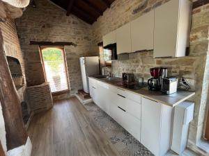 a kitchen with white cabinets and a refrigerator at La ferme des Soudanières in Ceyzériat