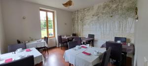 ein Restaurant mit Tischen und Stühlen und einer Landkarte an der Wand in der Unterkunft Auberge Côté Rivière in Is-sur-Tille