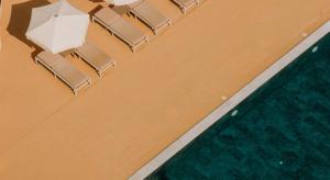 an overhead view of a swimming pool with chairs at Vrachia Beach Hotel & Suites - Adults Only in Paphos