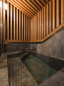 una piscina in una stanza con soffitto in legno di Toemon-湯右衛門- a Kyotango