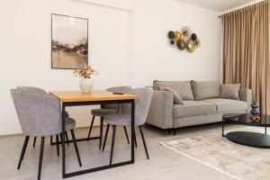 a living room with a table and a couch at Chindia Lake Suite in Târgovişte
