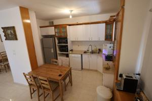 a small kitchen with a wooden table and a table and chairs at Vacation rental in Netanya +3 photos