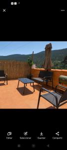 a patio with two chairs and a table and a umbrella at Los picarzos apartamento in Ayna +12 photos