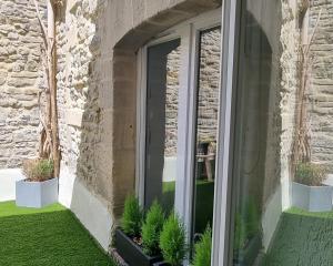 a window of a building with potted plants at La Signature - Appt 70m² pour 6 voyageurs in Bayeux