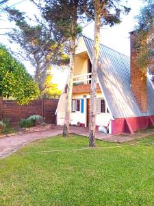 ein Haus mit zwei Bäumen im Garten in der Unterkunft Casa Alpina Frente al Mar - Aguas Verdes in Aguas Verdes