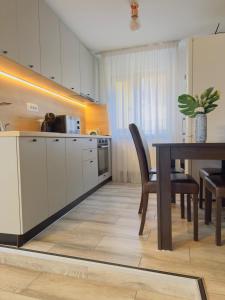 a kitchen with a table and a dining room at Casa de Vacanta Cris in Băile Olăneşti