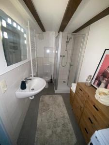 a white bathroom with a sink and a shower at Ferienwohnung Altstadt Frankenstraße in Stralsund +4 photos