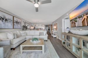 a living room with a white couch and a table at All New Oceanfront Luxury w Lazy River in Myrtle Beach +42 photos