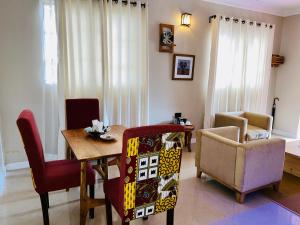a living room with a dining room table and chairs at The Dawn cottage in Moshi