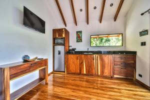 Beach resort playa Leona في Gigantes: مطبخ مع خزائن خشبية وتلفزيون على الحائط