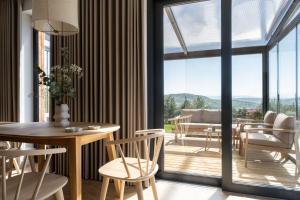 una sala da pranzo con tavolo e sedie e un balcone di Osada Tabaszowa a Tabaszowa