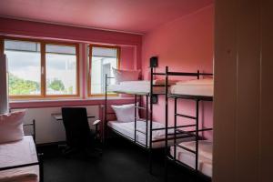 ein Zimmer mit drei Etagenbetten und einem Schreibtisch in der Unterkunft Bettenburg Hotel & Hostel in Hamburg