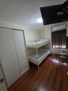 a room with a bunk bed and a flat screen tv at Magnífico alojamiento cerca de Mezquita catedral in Córdoba